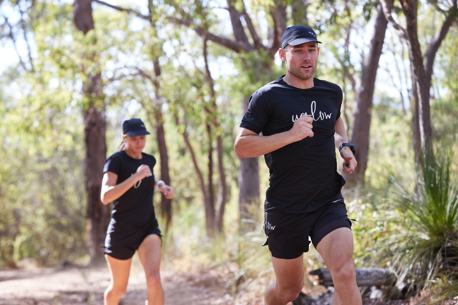 Løpende mann med svart caps med diskret hvit Uglow symbol.